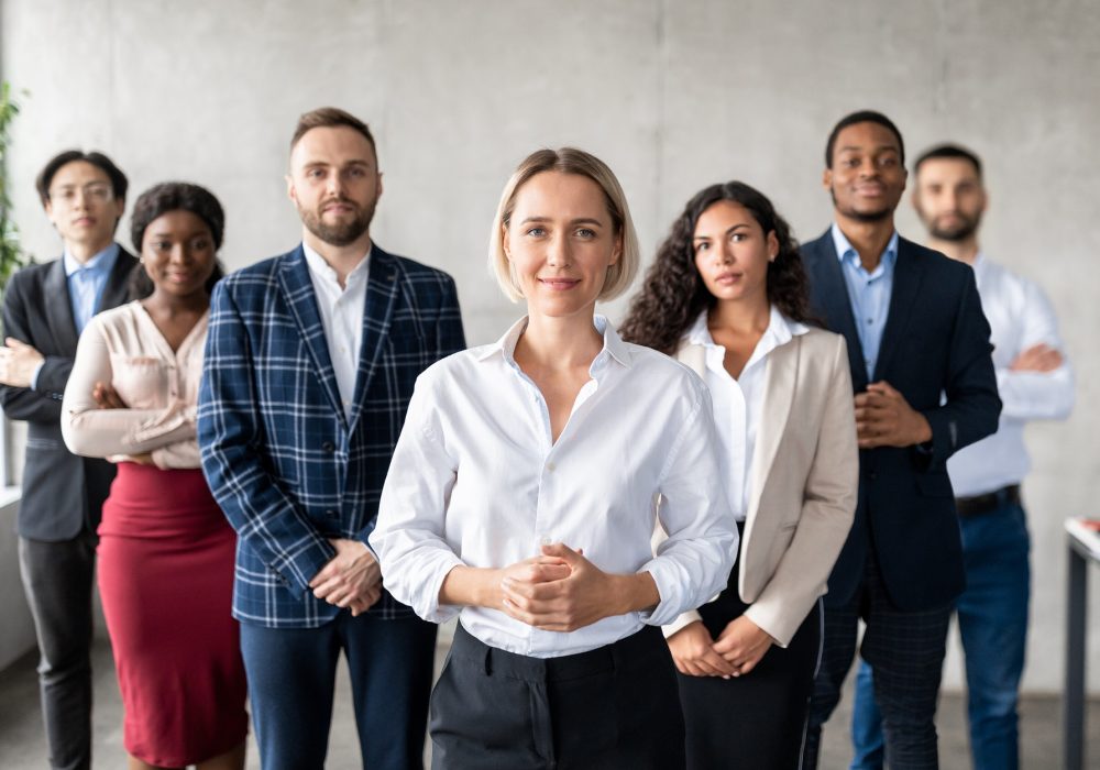 successful-businesswoman-standing-in-front-of-business-team-in-office.jpg